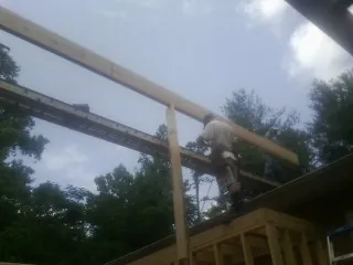 Carpenter setting a ridge beam over a new addition frame — Ice Dam Removal by Roofing Brothers in West Augusta