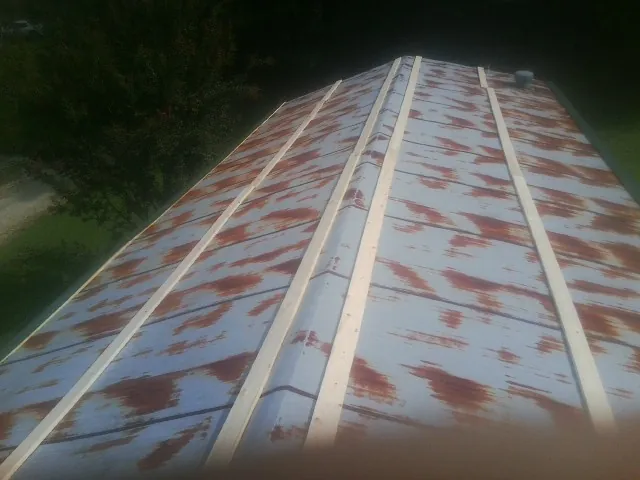 Rusted metal roof panels with new wood purlins before replacement — Storm Damage Roof Repair in West Augusta by Roofing Brothers