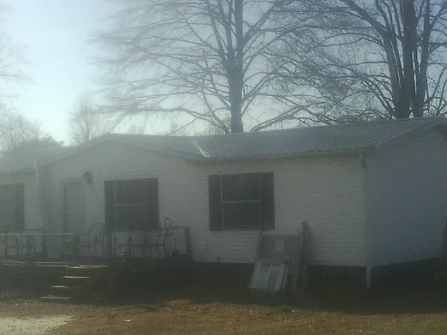 New metal roof on a white painted brick home on a foggy morning in West Augusta